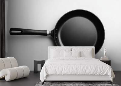 A black frying pan, or skillet, is shown on a plain white background. Wall mural