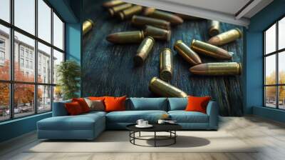 A bunch of rifle bullets are lying on a dark wooden surface. Wall mural