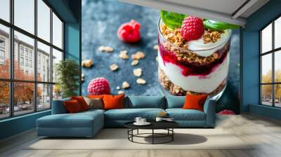 A delicious yogurt parfait in a glass. It has granola, raspberry sauce, fresh raspberries, and basil leaves. It's a healthy and low-carb dessert. Wall mural