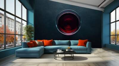 A glass of red wine or a hot drink, seen from above, against a dark backdrop. Wall mural