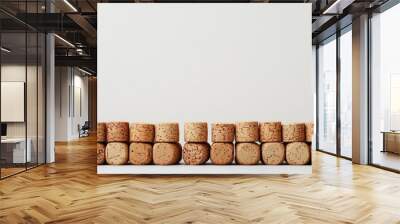 A row of wine corks against a plain white backdrop.  They're up close, so you can see all the details. Wall mural