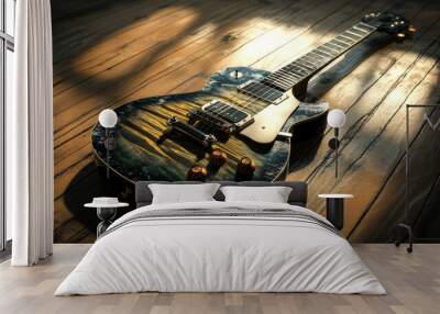 A shiny electric guitar sits on a wooden surface, illuminated by a bright light. Wall mural