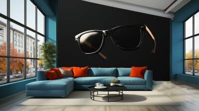 Sunglasses floating in the air against a black background. Wall mural