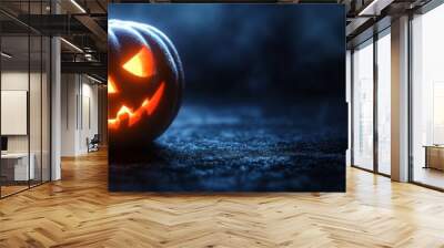 A carved Halloween pumpkin glows brightly against a dark background, casting eerie shadows that enhance the spooky ambiance of the festive season Wall mural