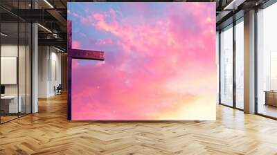 A close-up image of a wooden cross silhouetted against a vibrant sunset sky, symbolizing the Easter theme Wall mural