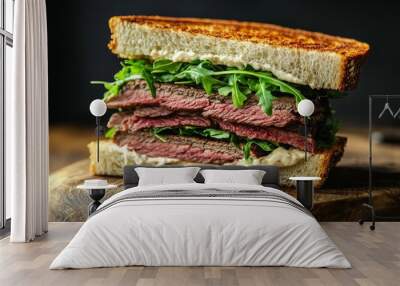 A gourmet sandwich features layers of roast beef and fresh arugula, generously spread with creamy horseradish sauce and served on toasted bread Wall mural