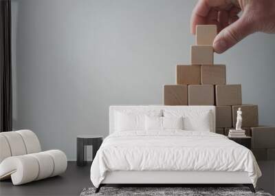 A hand is seen rotating one of the wooden blocks in a strategic stack, illustrating the importance of adaptability and planning in business. The clean background enhances the focus on the action Wall mural