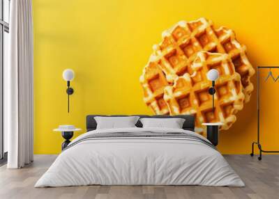 A stack of golden brown waffles sits beautifully centered against a vibrant yellow background, inviting a delicious breakfast experience Wall mural