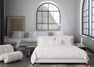 An old, distressed coffee table is placed next to a white sofa in a contemporary living area. Large arched windows allow soft natural light to illuminate the room Wall mural