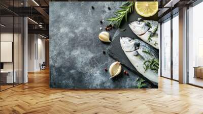 Raw dorado fish is artfully arranged on a grey slate board, surrounded by fresh rosemary, garlic, and lemon slices, showcasing its vibrant appeal Wall mural