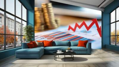 The visual demonstrates a financial analysis with stacked bar graphs showcasing trends, while red arrows indicate a decline in market performance, set against stacks of coins Wall mural