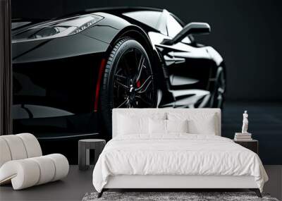 A sleek black sports car is parked in a dark garage. The car is lit by a single spotlight, which highlights its contours and curves. Wall mural