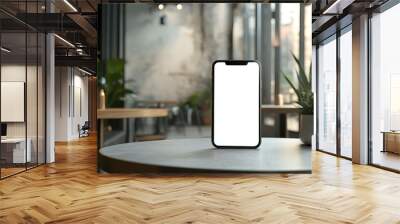 Blank screen smartphone on table in modern cafe. Wall mural