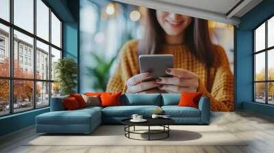 Close up of a woman using a smartphone in a coffee shop. Wall mural