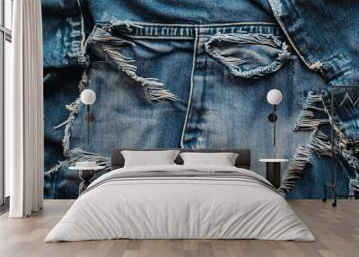 Close up of ripped blue jeans, showing detail of frayed edges. Wall mural