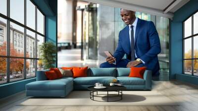 African american businessman smiling cheerful, using cell phone at office building, internet, broadband, 5G, copy space  Wall mural