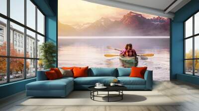 An adventurous couple in kayak paddle on a lake with rocky mountain background, Inspirational travel and leisure recreational, peaceful serene isolation Wall mural