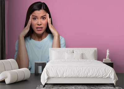 Anxious female worried and concerned, having inner conflict, stress, anxiety, isolated on pink background, copy space Wall mural