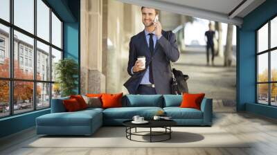 attractive commuter walking downtown with coffee and briefcase Wall mural