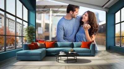 Attractive fun young couple in love playful and full of energy hug and laugh Wall mural