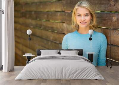 Beautiful blonde woman portrait smiles next to wood fence Wall mural