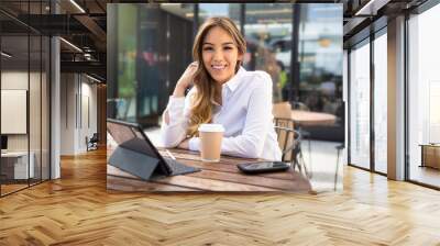 Portrait of a beautiful mixed ethnicity latin female student entrepreneur, working from laptop at coffee shop Wall mural