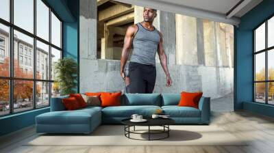 Strong male athlete in sportswear stretching legs, preparing for city jog, urban fitness and exercise Wall mural