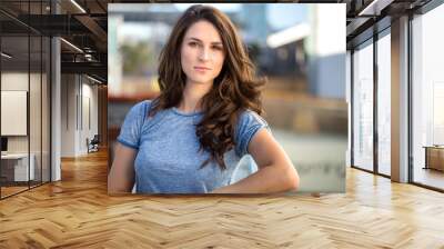 Youthful brunette headshot serious expression in thought, possible staff worker Wall mural