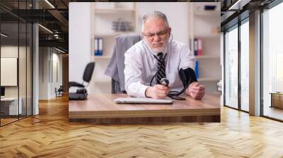 Aged male employee suffering at workplace Wall mural