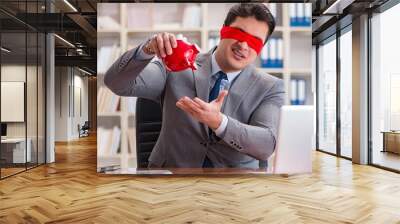 Blindfold businessman sitting at desk in office Wall mural