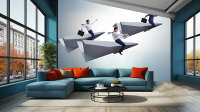 Businessman flying on paper plane in business concept Wall mural