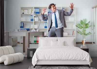 Businessman having fun taking a break in the office at work Wall mural