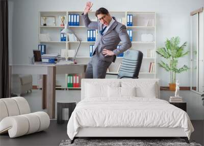 Businessman having fun taking a break in the office at work Wall mural