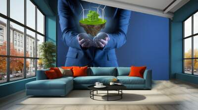 Businessman holding flying island in eco concept Wall mural