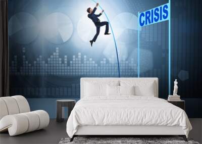 Businessman pole vaulting over crisis in business concept Wall mural