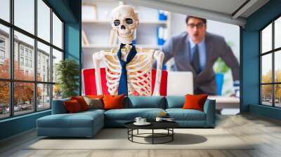 Businessman working with skeleton in office Wall mural