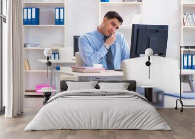 Handsome businessman employee sitting at his desk in office Wall mural