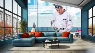 Male cook preparing food in the kitchen Wall mural