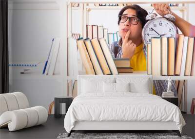 Male student preparing for exams at library  Wall mural