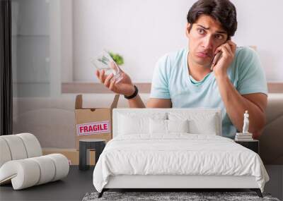 Man opening fragile parcel ordered from internet Wall mural