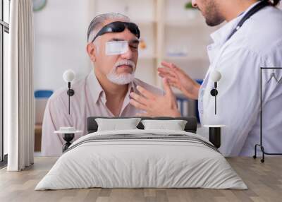 Old blind man visiting young male doctor Wall mural