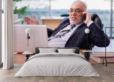 Old businessman employee working in the office Wall mural