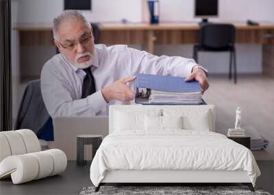 Old male employee unhappy with excessive work in the office Wall mural