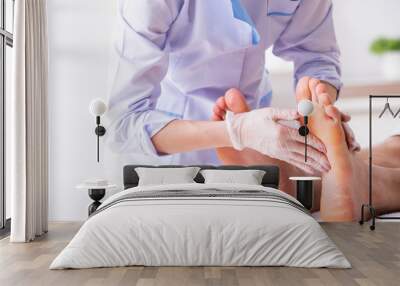 Podiatrist treating feet during procedure Wall mural