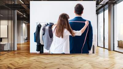 Professional tailor taking measurements for formal suit Wall mural