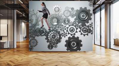 Woman businesswoman walking in cogwheels Wall mural