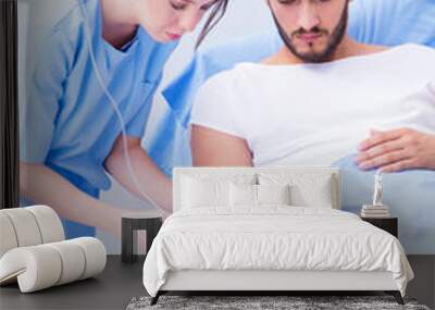 Woman doctor examining male patient in hospital Wall mural