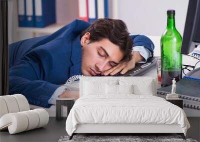 Young businessman employee drinking in the office at desk Wall mural