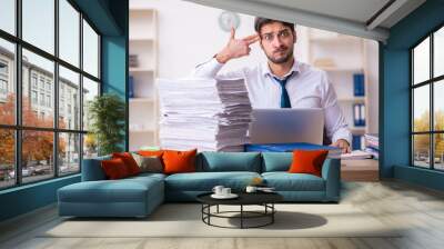 Young businessman employee unhappy with excessive work in the office Wall mural