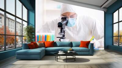 Young chemist student working in lab on chemicals Wall mural